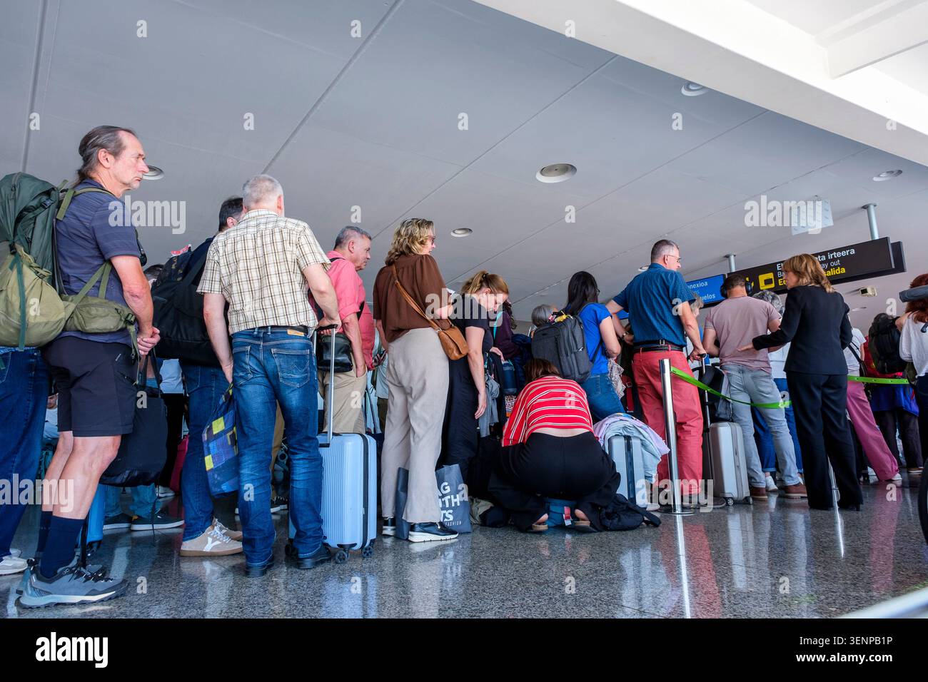 les passagers se mettent en file avec leurs bagages pour le contrôle des billets et des identités avant l'embarquement. | les passagers font la queue avec le Banque D'Images