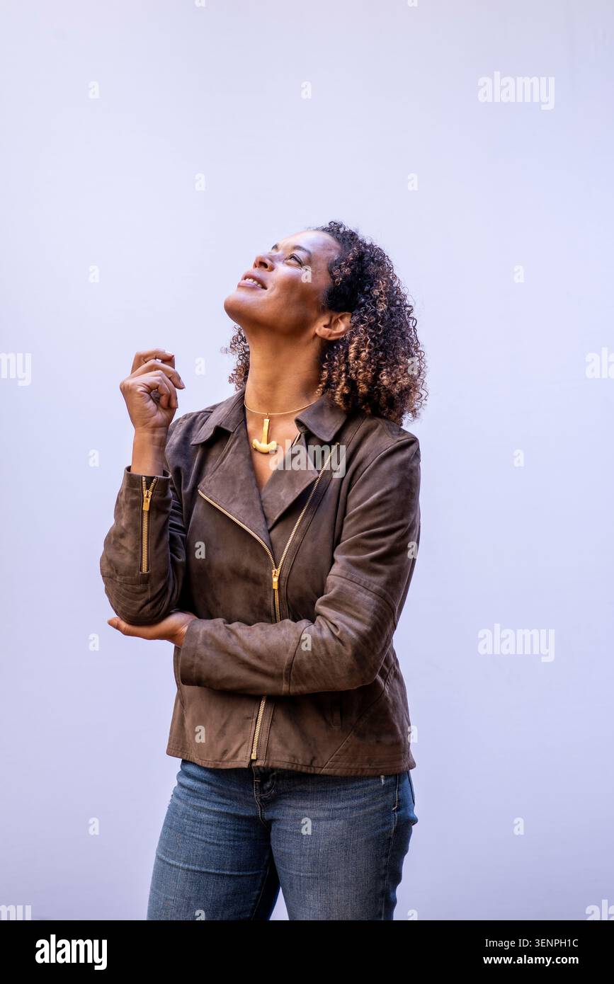 Aminatta Forna se trouve dans un studio avec un éclairage doux. Elle lève les yeux en pensant en posant. Le décor capte son expression et sa présence. C'est un Banque D'Images