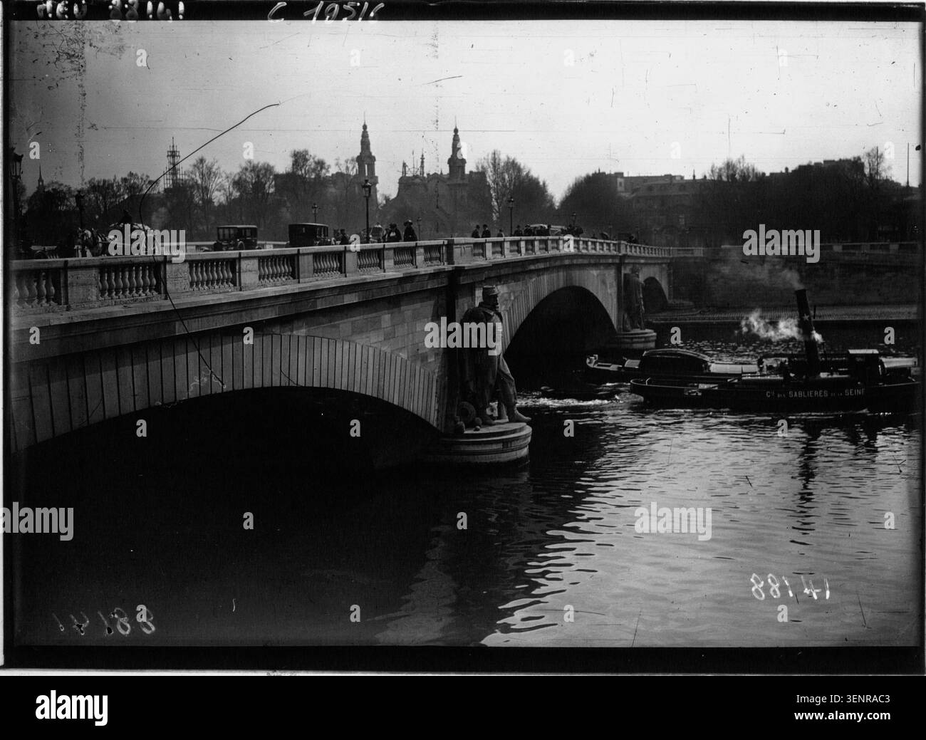 Une photographie de presse datant de 1921 montre le bas niveau des eaux de la Seine au Pont de l'Alma lors d'une sécheresse à Paris. L'image se concentre sur la rivière et les structures urbaines environnantes affectées par le débit réduit. Banque D'Images