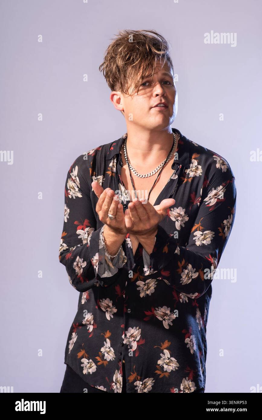 Portrait du poète de performance Luke Wright en chemise lumineuse. Il a des cheveux sauvages et est très expressif dans son langage corporel Banque D'Images