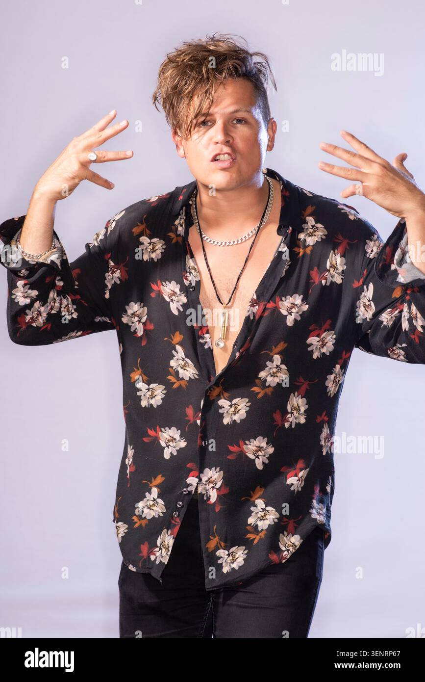 Portrait du poète de performance Luke Wright en chemise lumineuse. Il a des cheveux sauvages et est très expressif dans son langage corporel Banque D'Images