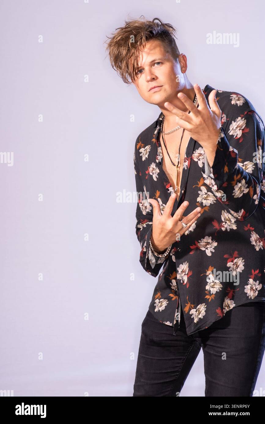 Portrait du poète de performance Luke Wright en chemise lumineuse. Il a des cheveux sauvages et est très expressif dans son langage corporel Banque D'Images