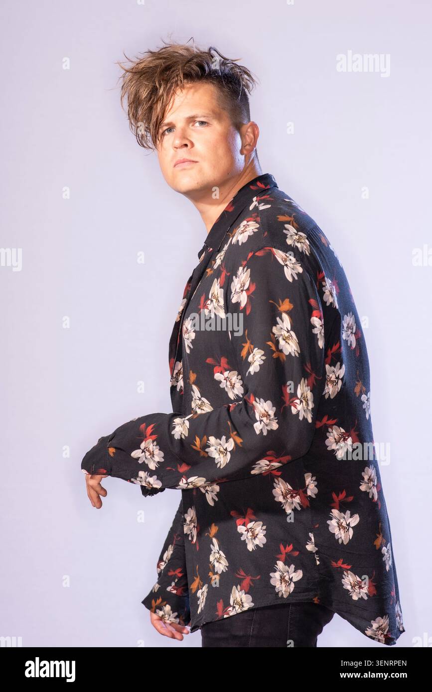 Portrait du poète de performance Luke Wright en chemise lumineuse. Il a des cheveux sauvages et est très expressif dans son langage corporel Banque D'Images