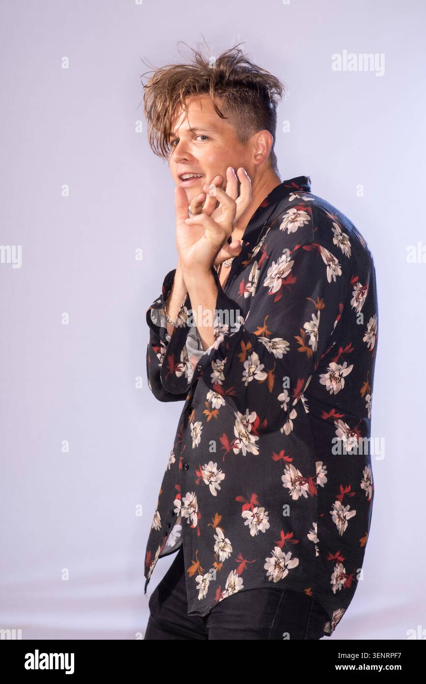 Portrait du poète de performance Luke Wright en chemise lumineuse. Il a des cheveux sauvages et est très expressif dans son langage corporel Banque D'Images