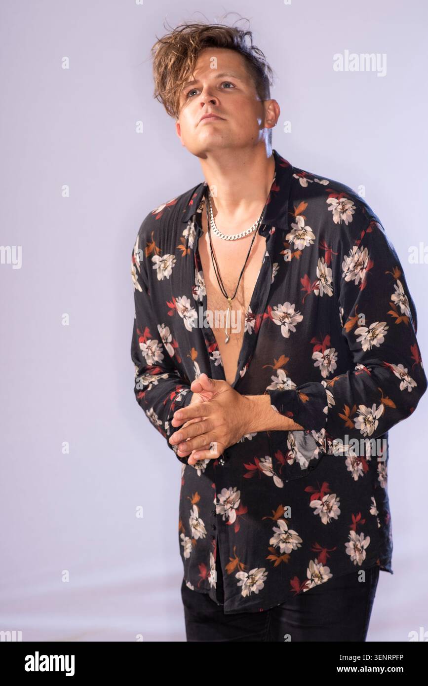 Portrait du poète de performance Luke Wright en chemise lumineuse. Il a des cheveux sauvages et est très expressif dans son langage corporel Banque D'Images