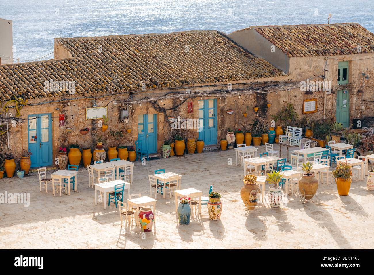 Marzamemi Italie tables et chaises de café en plein air installées au bord de la mer Banque D'Images