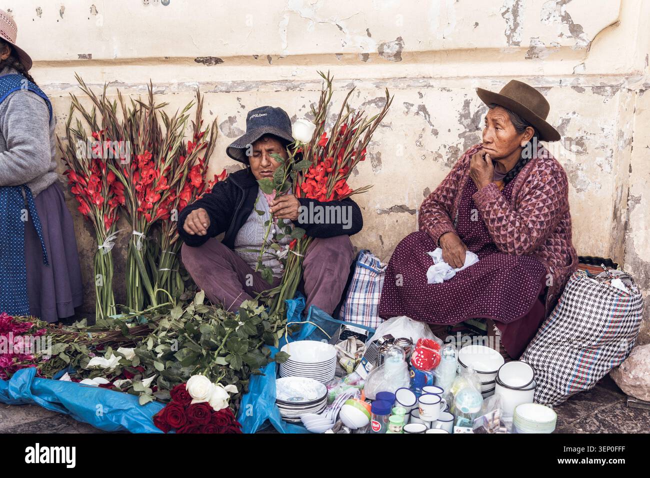 Cusco, Pérou - 23 mars 2025 : deux femmes péruviennes indigènes vendent des fleurs et des articles ménagers à l'extérieur du marché San Pedro, Cusco Banque D'Images