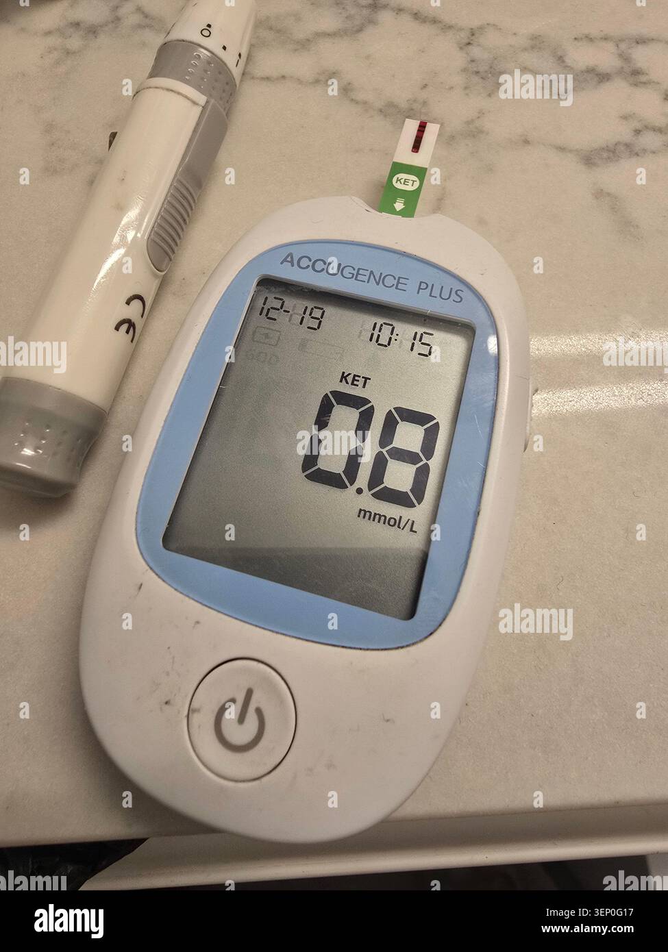 Glucomètre avec bandelette de test et stylo autopiqueur sur un comptoir en marbre, montrant une lecture élevée de sucre pour le dépistage du diabète, la surveillance à domicile et la guérison Banque D'Images