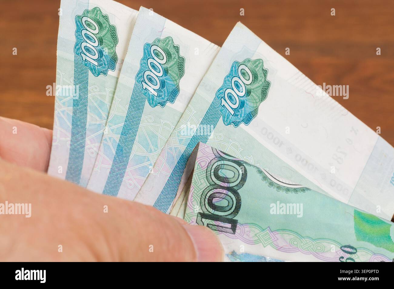 Gros plan d'un billet russe de mille roubles dans une main Banque D'Images