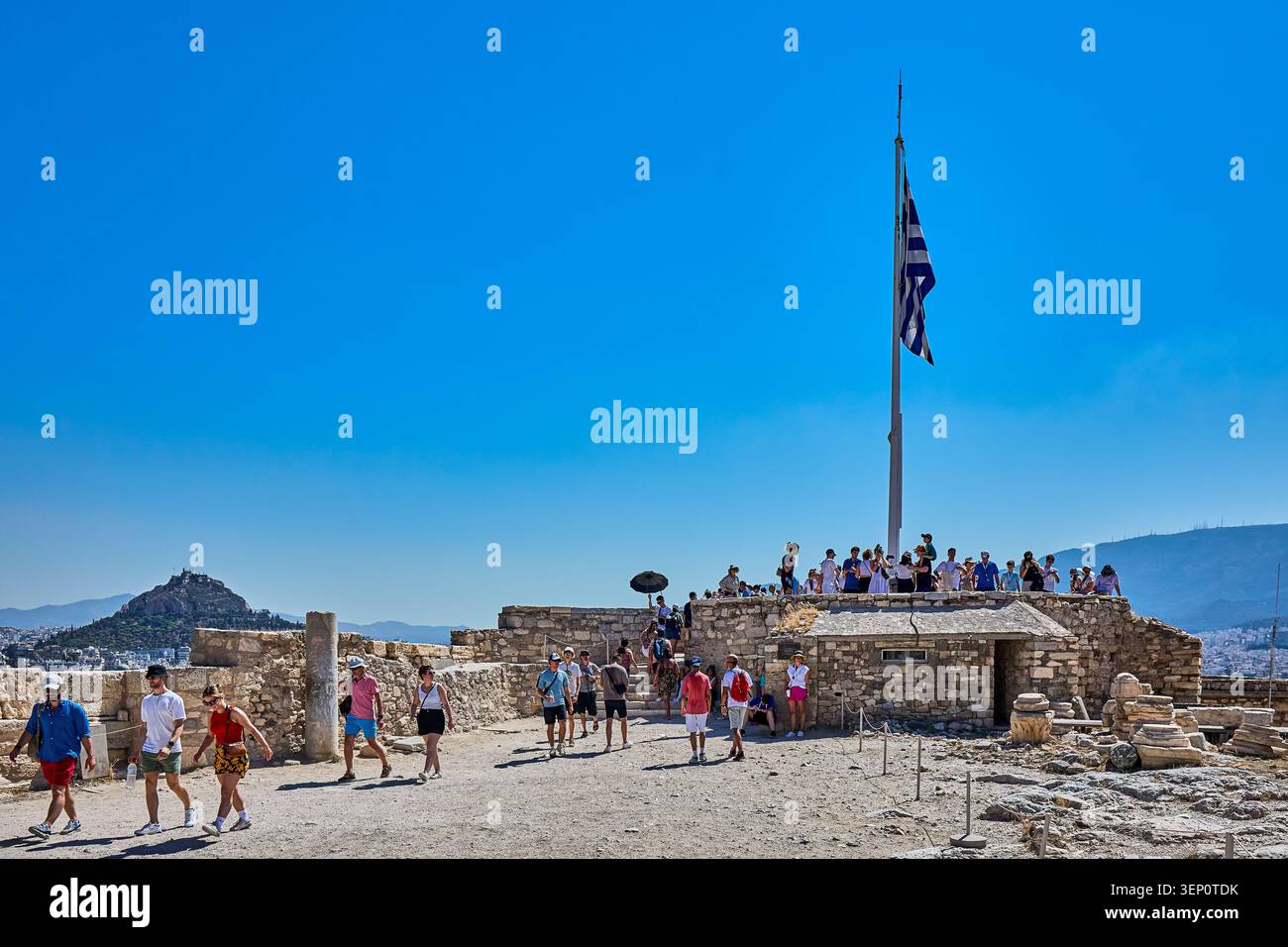 Touristes debout à un point de vue à l'Acropole avec le drapeau de la Grèce, ceci étant un point d'observation et guet pour une vue sur la ville d'Athènes Banque D'Images