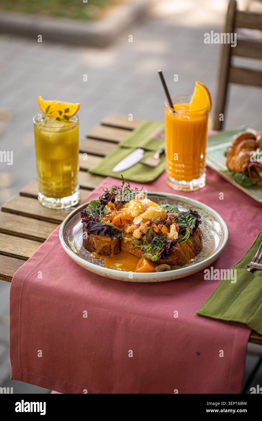 Brioche toast avec oeuf poché et boissons fraîches Banque D'Images