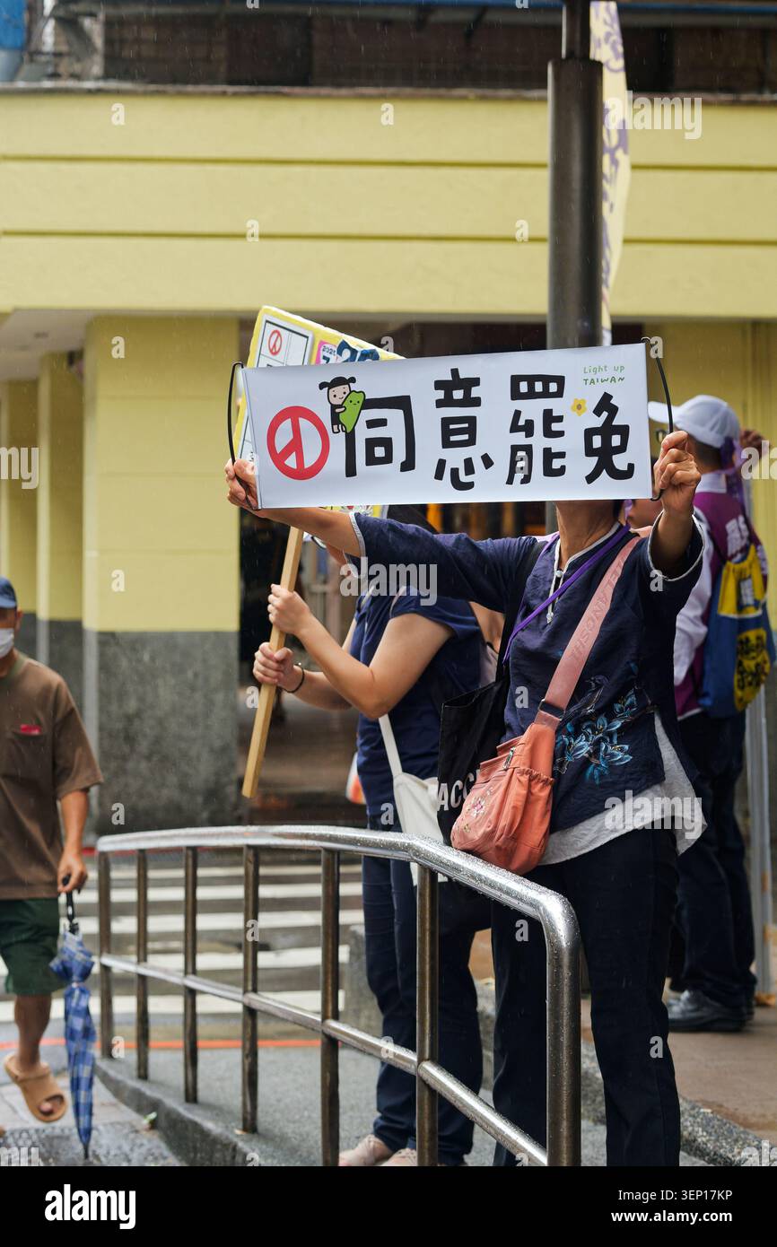 Taipei, Taïwan - 19 juillet 2025 : visage du volontaire caché par la bannière blanche "accepter de rappeler" avec le symbole de la paix pendant le mouvement de rappel de masse de Taïwan. Banque D'Images
