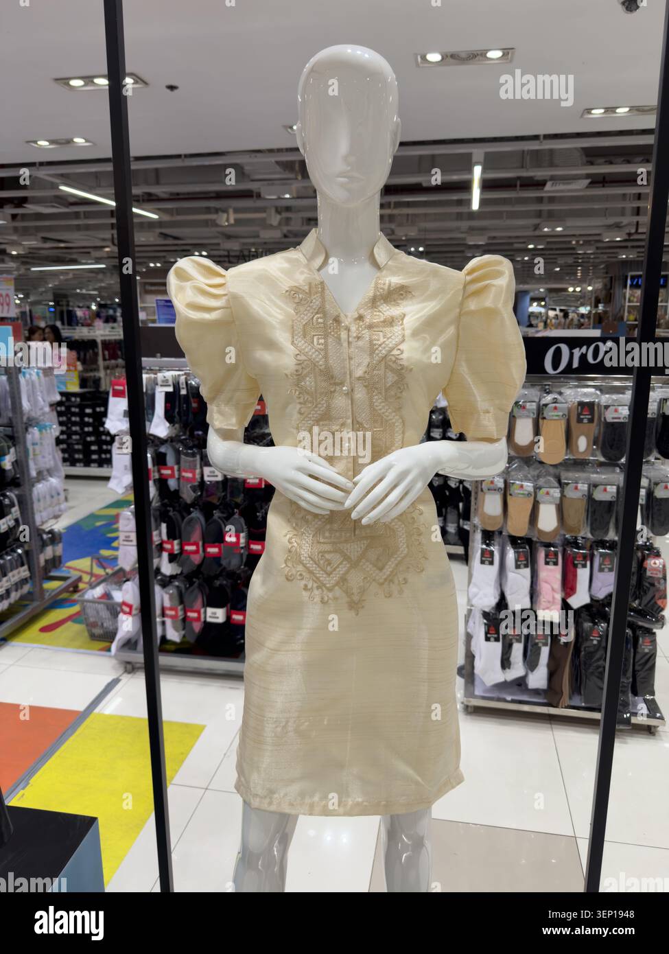 Robe philippine crème avec manches papillons traditionnelles et détails brodés affichés dans un magasin de détail philippin. - Image de stock capturée avec un smartphone
