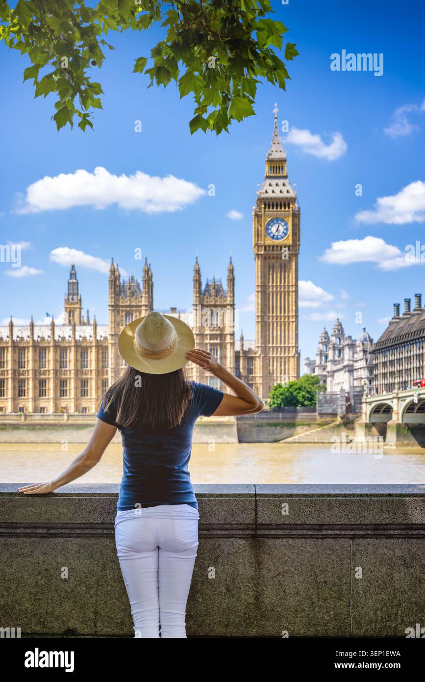 Vue arrière d'une femme touriste debout devant la tour de l'horloge Big Ben à Londres, en Angleterre, pendant une journée d'été ensoleillée Banque D'Images