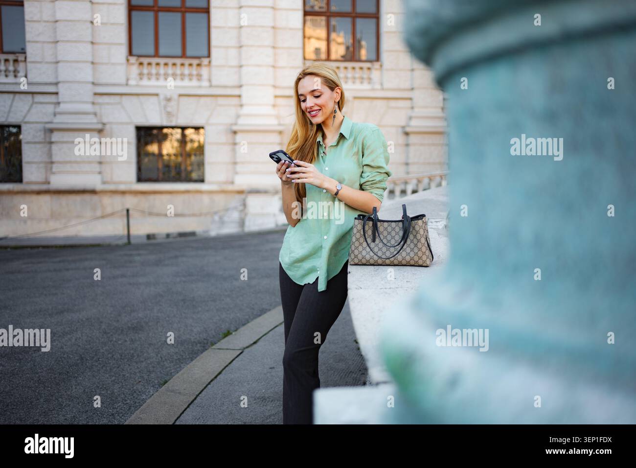Femme textant sur smartphone dans la rue de la ville de Vienne Banque D'Images