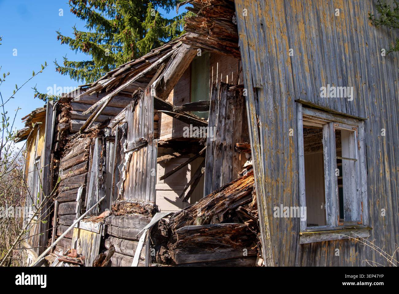 Maison en bois abandonnée gravement détériorée avec des murs effondrés et une structure intérieure exposée montrant une dégradation et une négligence avancées Banque D'Images