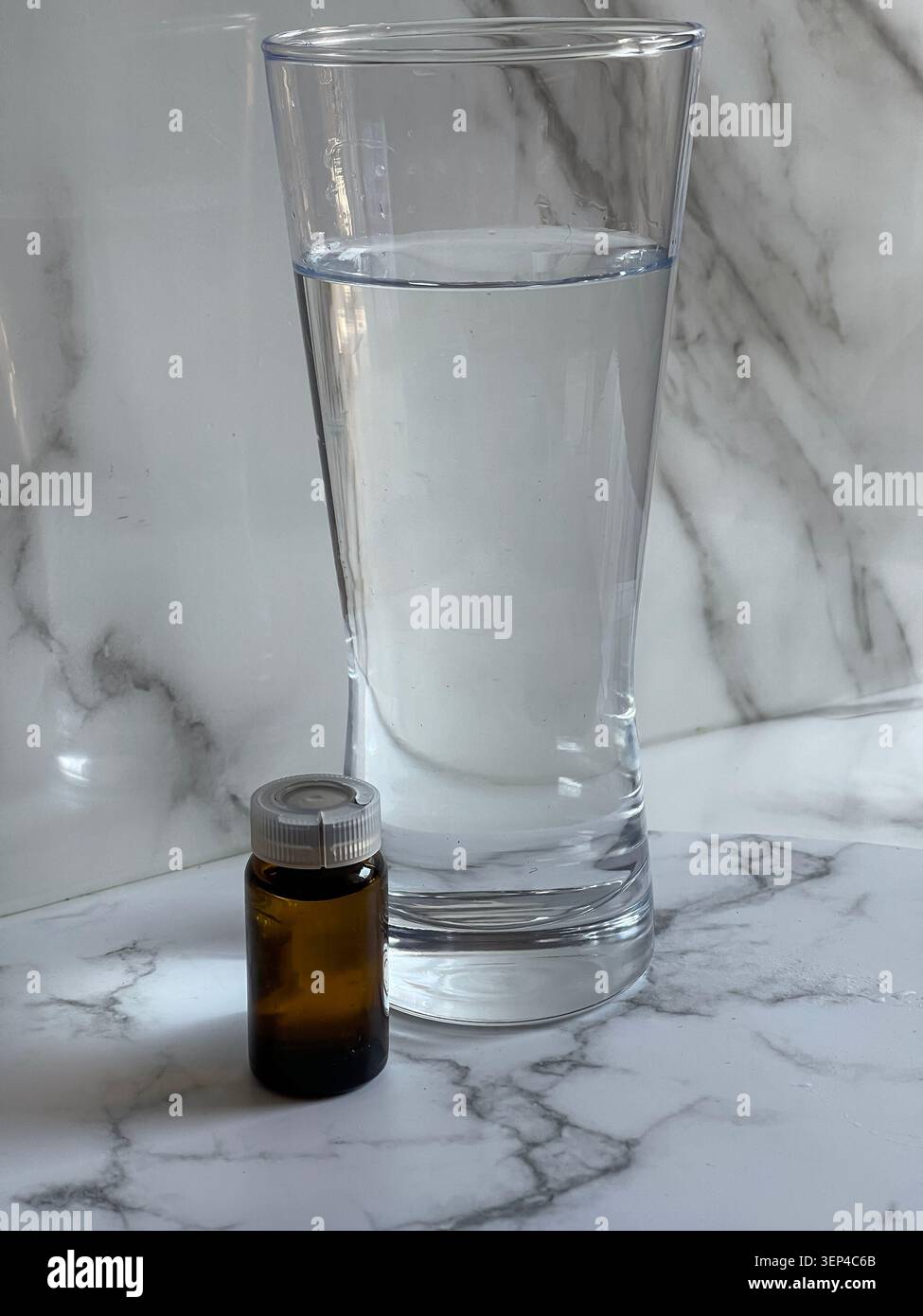 Bouteille de supplément de magnésium avec un verre d'eau pour la routine quotidienne de santé. - Image de stock capturée avec un smartphone