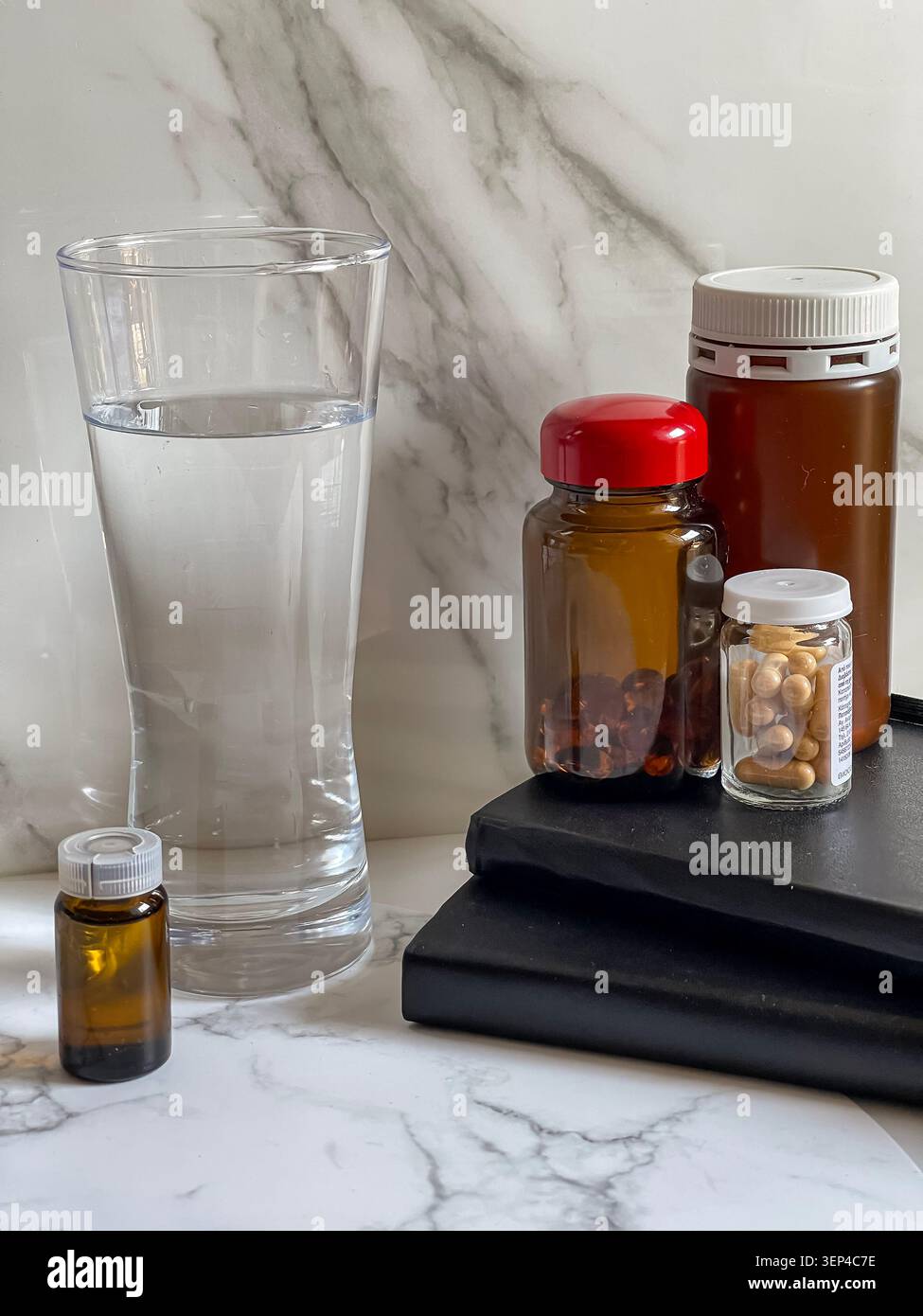 Suppléments vitaminiques avec un verre d'eau représentant un mode de vie sain et une routine de bien-être quotidienne. - Image de stock capturée avec un smartphone