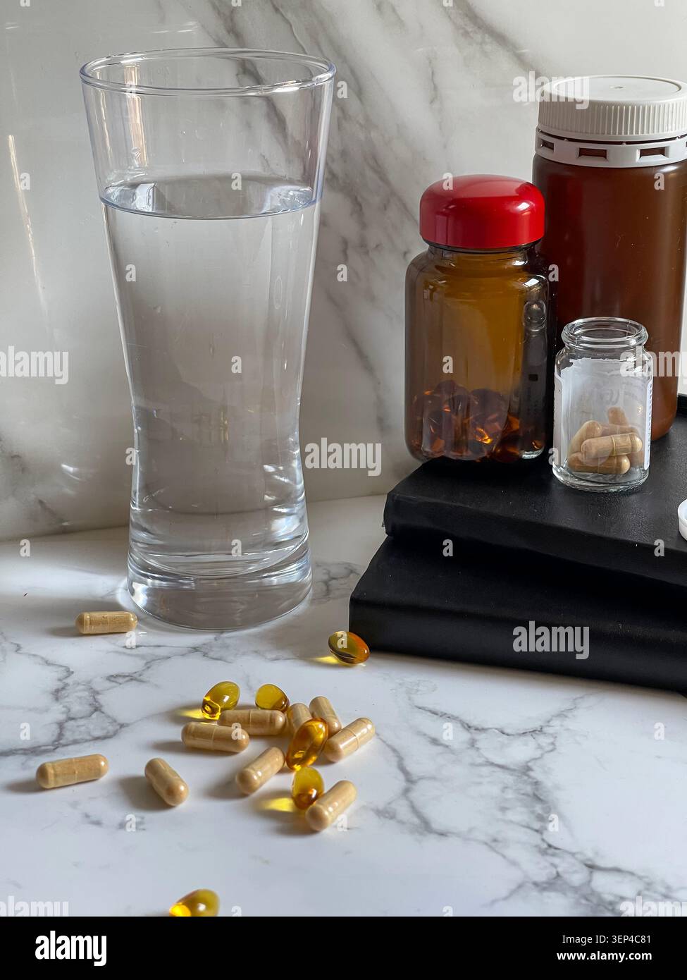 Suppléments vitaminiques avec un verre d'eau représentant un mode de vie sain et une routine de bien-être quotidienne. - Image de stock capturée avec un smartphone