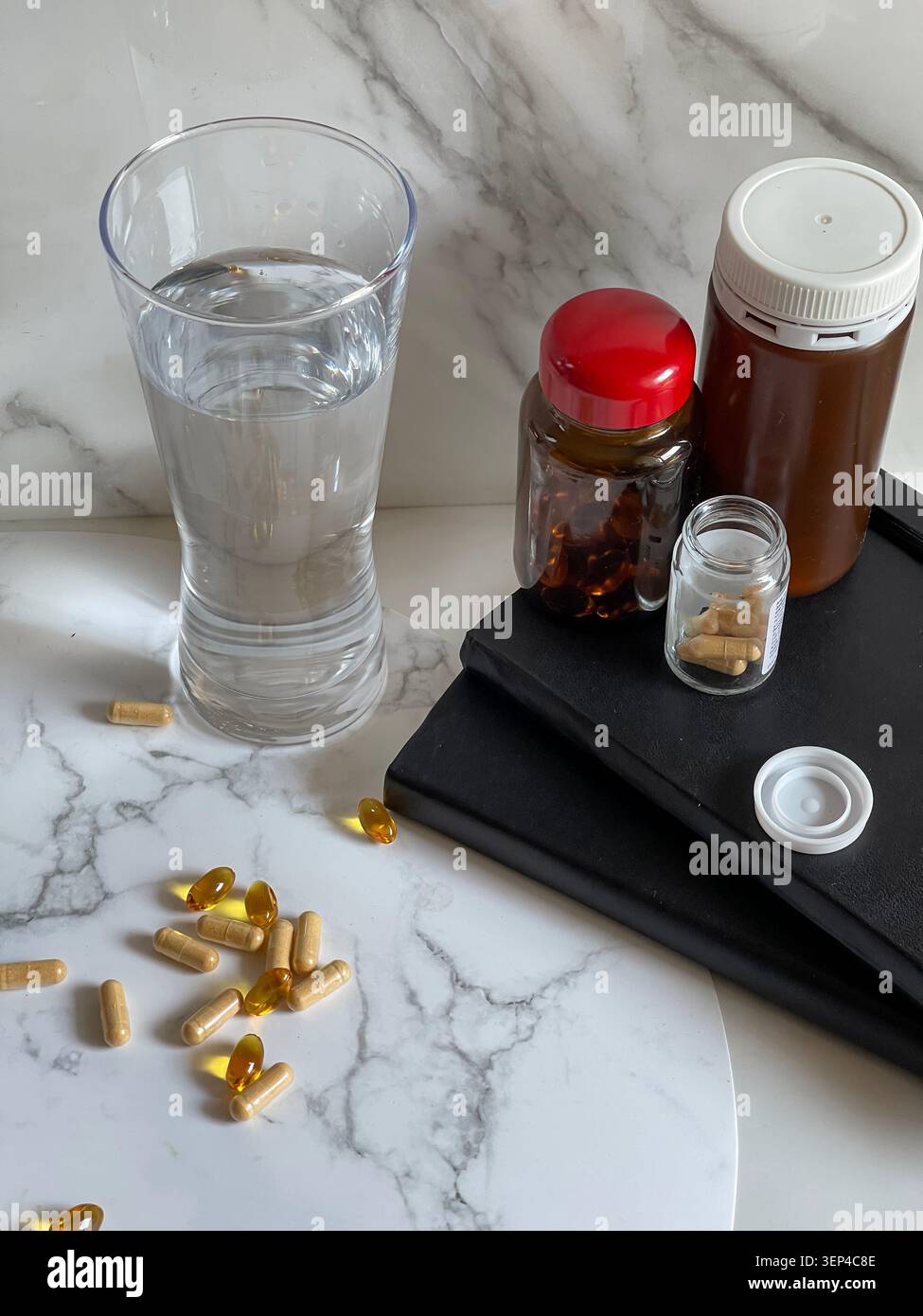 Suppléments vitaminiques avec un verre d'eau représentant un mode de vie sain et une routine de bien-être quotidienne. - Image de stock capturée avec un smartphone