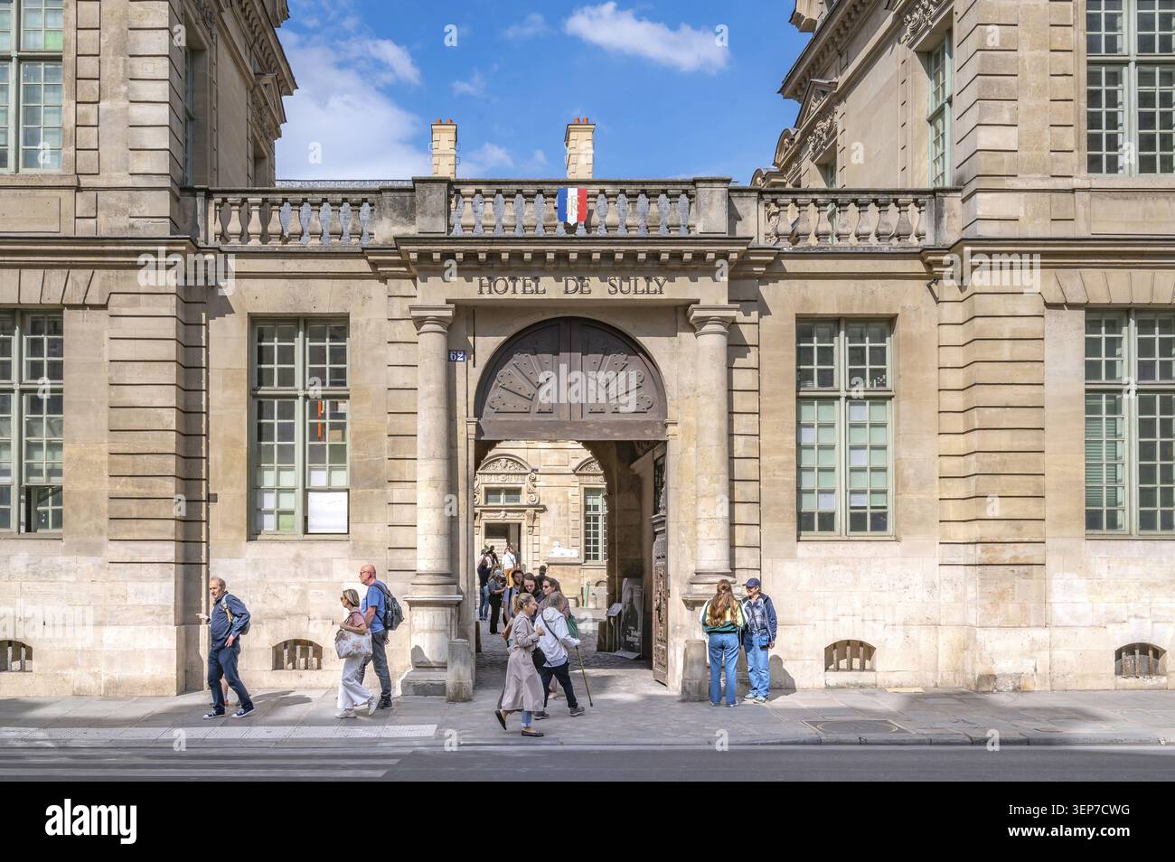 Passants et visiteurs devant la porte d'entrée monumentale avec le lettrage HOTEL DE SULLY sculpté dans la façade en grès côté rue de th Banque D'Images