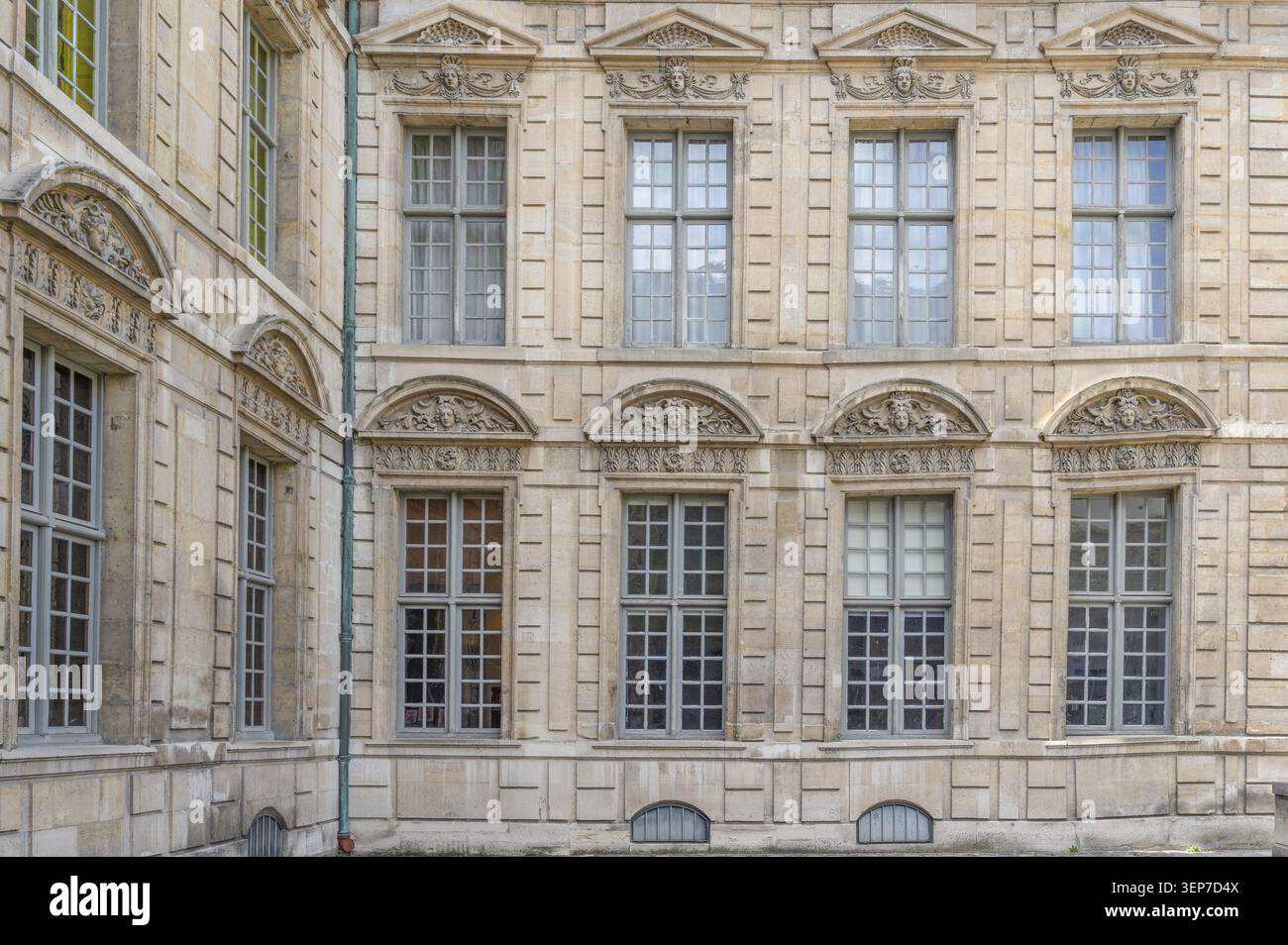 Disposition symétrique grandes fenêtres en treillis et fronton en relief orné sur la façade historique en grès de l'Hôtel de Sully comme symbole de classi Banque D'Images