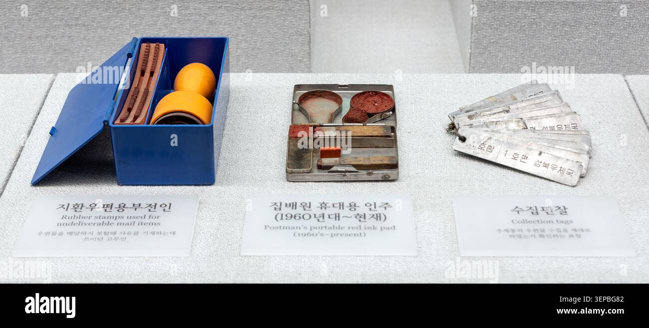 Trois objets personnels transportés par des facteurs, dont des timbres en caoutchouc, un tampon encreur portable et des étiquettes de collection, exposés au Musée postal de Cheonan Banque D'Images