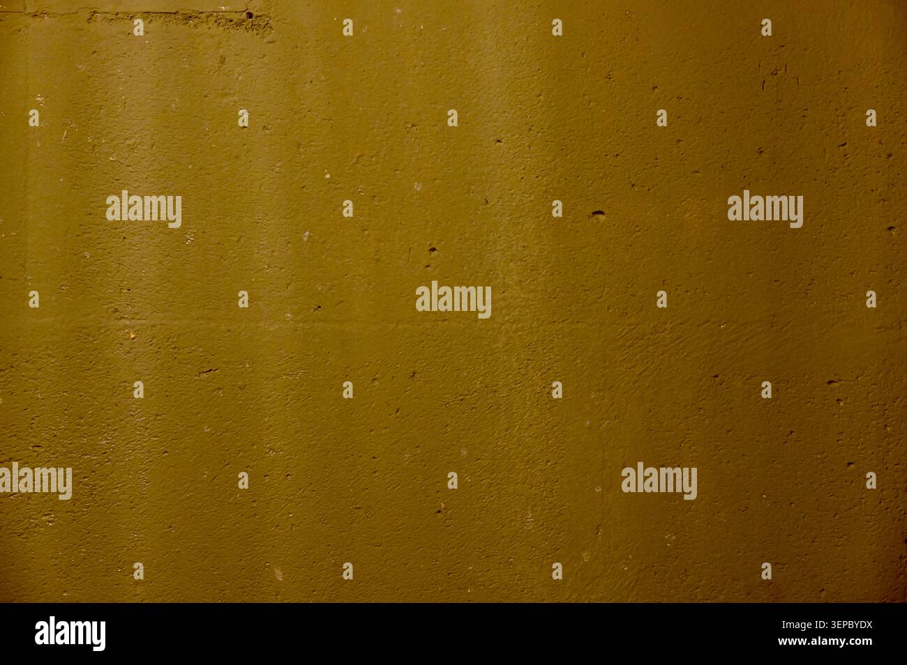 Une belle macro texture horizontale d'un mur de béton jaune moutarde solide avec une surface granuleuse fine. La composition est entièrement remplie de t Banque D'Images