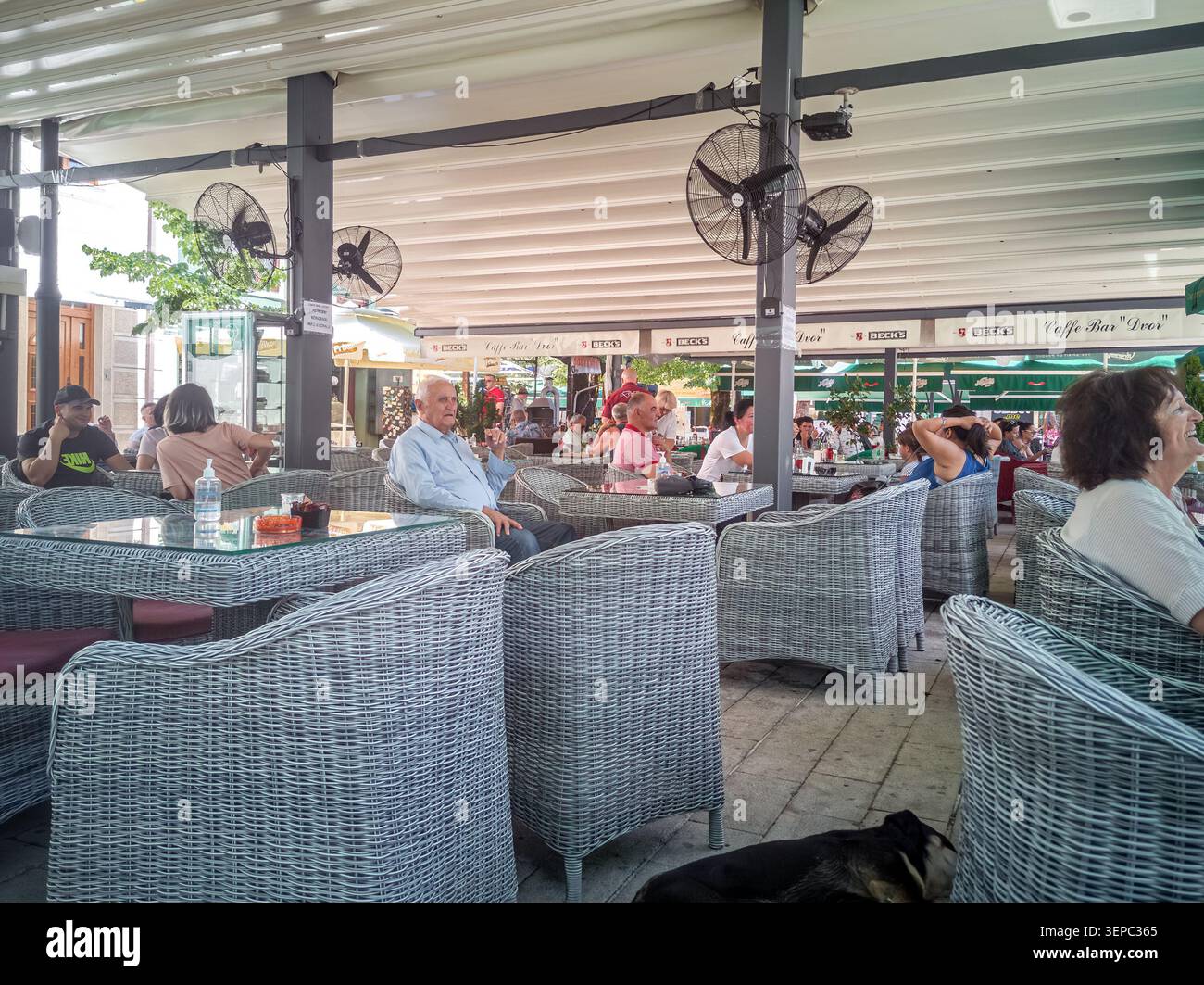 Les gens se détendent au Caffe Bar Dvor sur la rue Njegoseva à Cetinje. Cette terrasse confortable est un endroit populaire au Monténégro. Cetinje, Monténégro - 20 juin 2021 - Image de stock capturée avec un smartphone