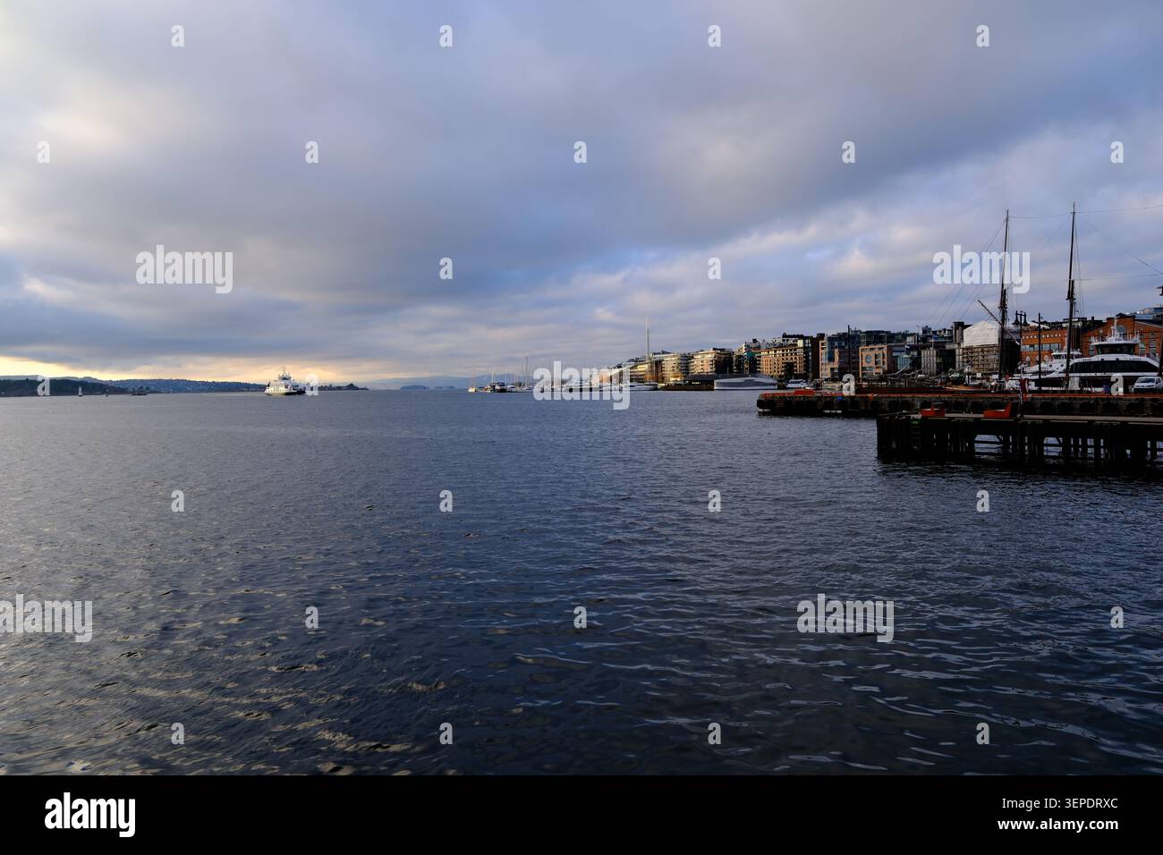 Oslo, Norvège-Nov.26th 2025 : Rådhusbrygge et le front de mer de la ville d'Oslo, Norvège, avec une mer calme par une journée nuageuse Banque D'Images
