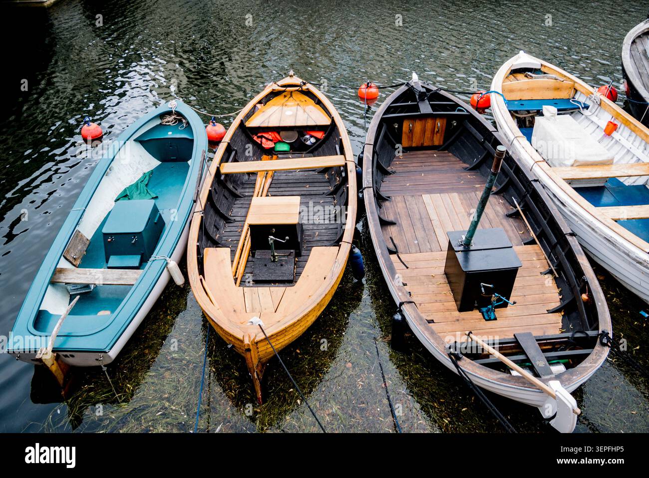 Bateaux à rames traditionnels en bois amarrés côte à côte dans un canal de Copenhague, Danemark. Patrimoine maritime scandinave et artisanat. Banque D'Images