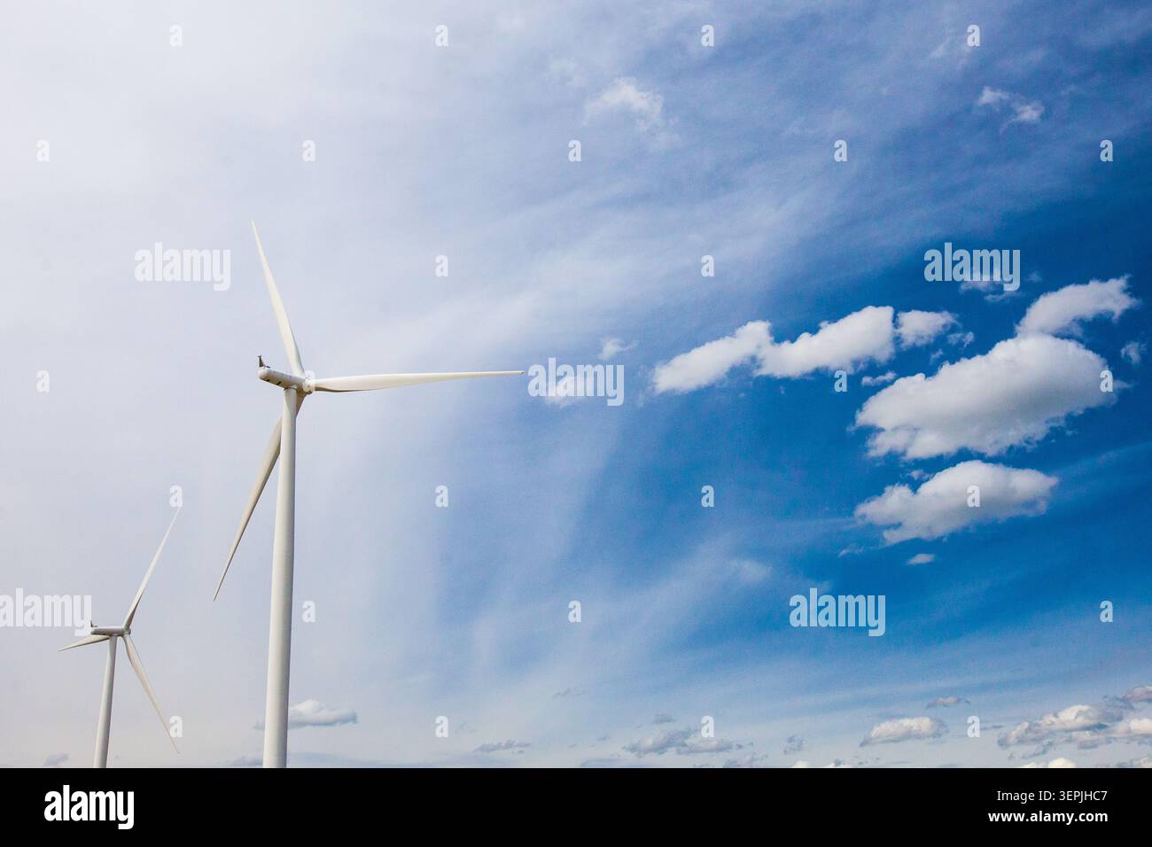 Deux éoliennes contre un ciel partiellement nuageux Banque D'Images