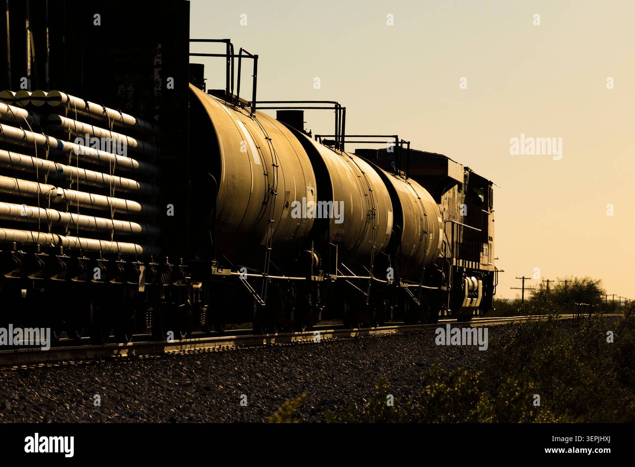 Train de marchandises avec wagons-citernes à l'heure dorée Banque D'Images