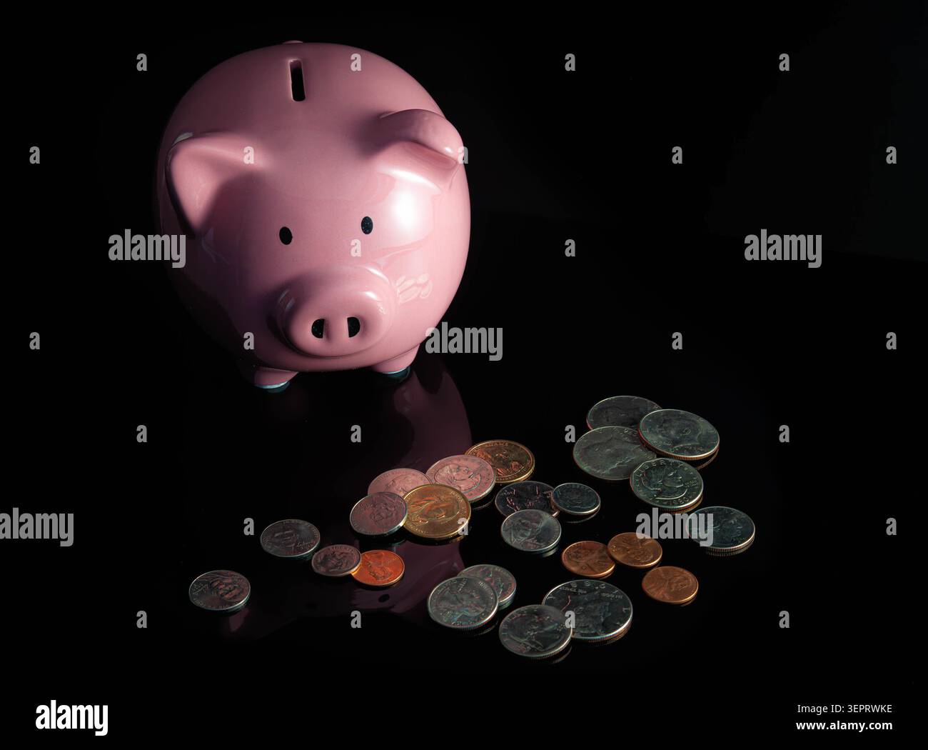 TITRE Piggy Bank rose avec des pièces dispersées sur la surface noire représentant l'épargne, le budget et la planification financière Banque D'Images