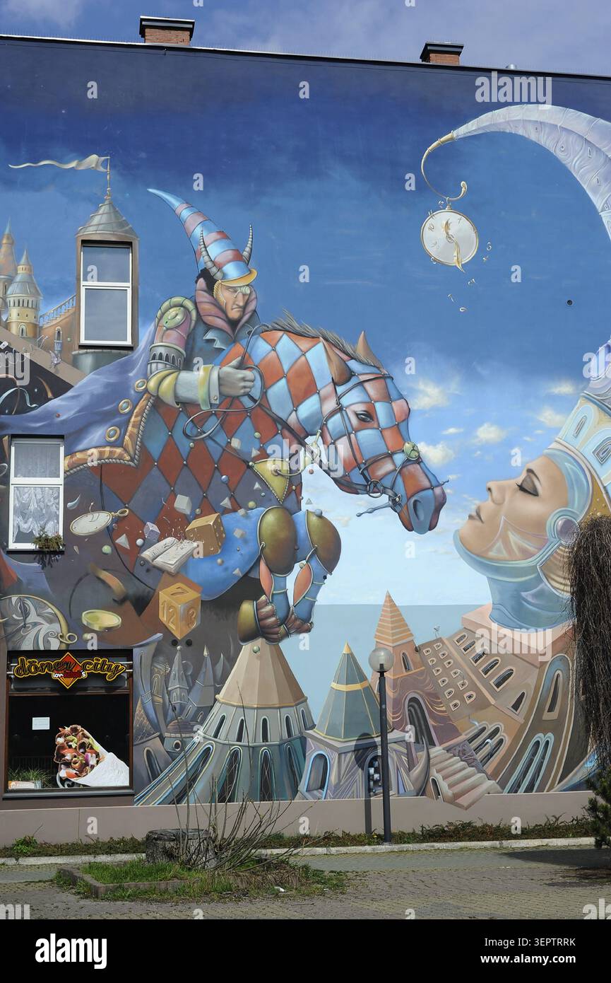 Murale fantaisie colorée représentant un cavalier arlequin et un cheval peints sur la façade d'un bâtiment à Czestochowa, en Pologne Banque D'Images