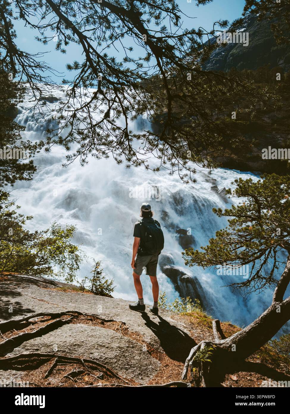 Homme voyage touristique en solo en Norvège randonneur vacancier profitant de la vue sur la cascade Explorer Husedalen, voyageur masculin sur les vacances d'été aventure saine l Banque D'Images