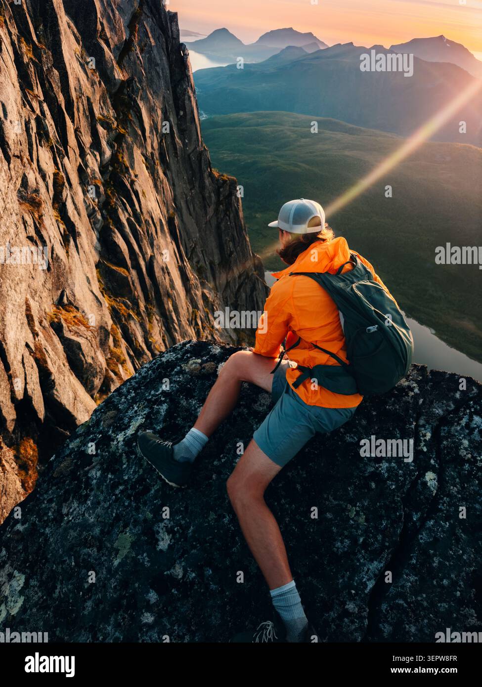 Brave homme regardant vers le bas du bord de la falaise de montagne voyage solo en Norvège escalade extrême vacances d'été aventure voyage en plein air, voyageur avec dos Banque D'Images