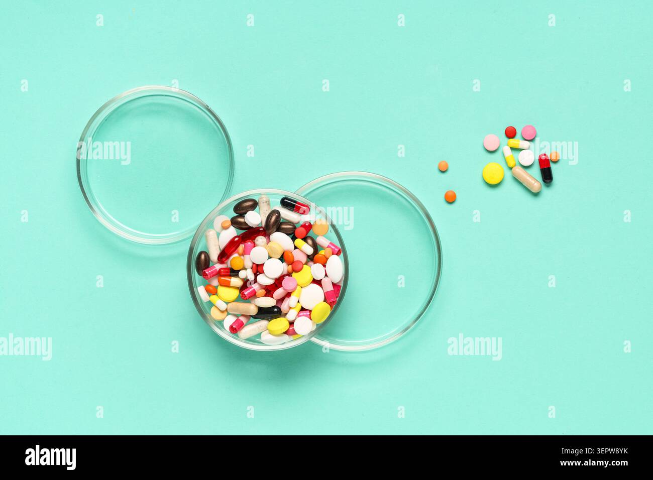Pilules et capsules pharmaceutiques colorées dans des boîtes de Petri sur un fond bleu clair, recherche médicale et soins de santé, médecine Banque D'Images