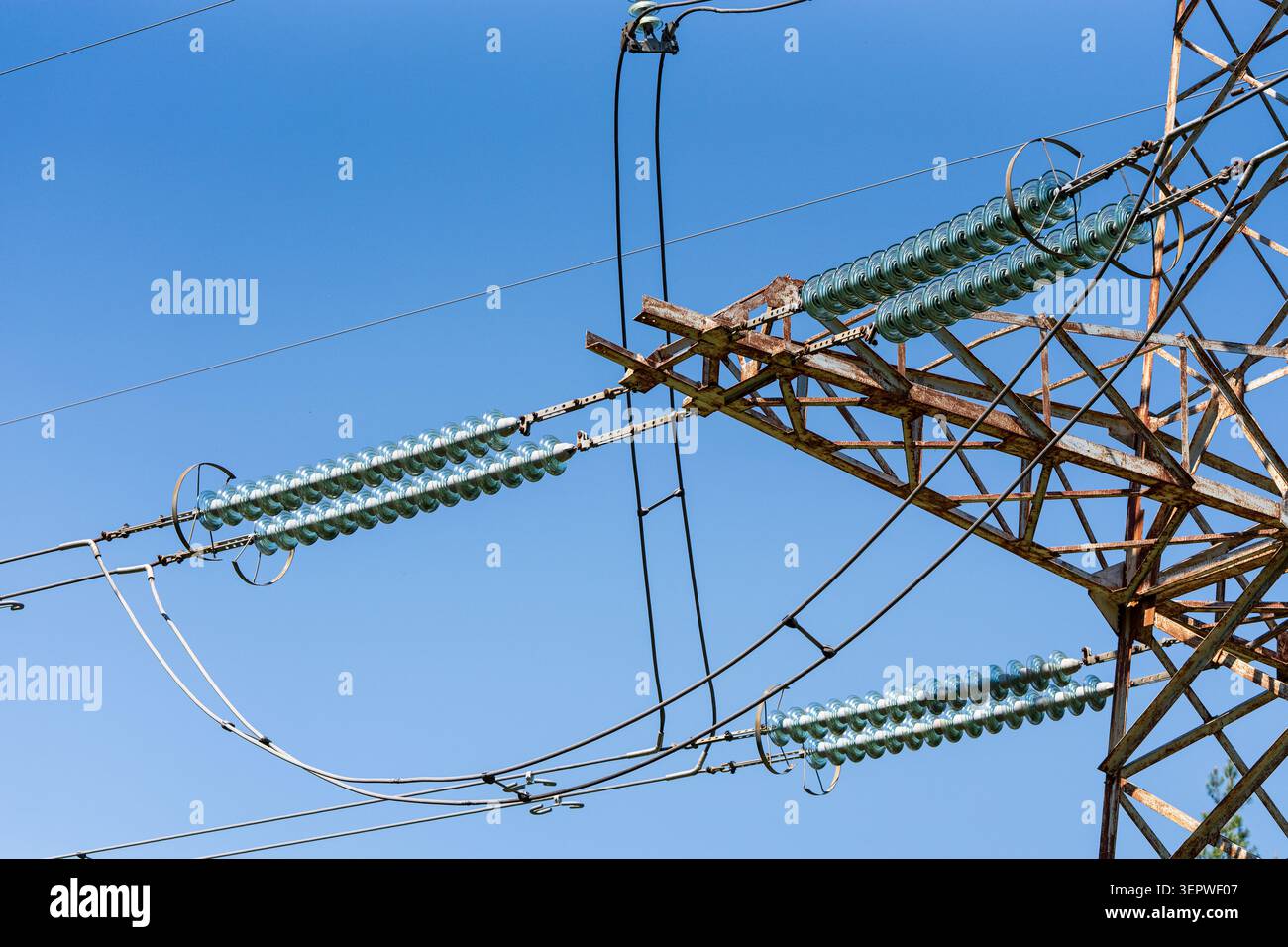 Pylône de ligne électrique à haute tension avec isolants en verre et câbles électriques contre un ciel bleu avec des nuages blancs, transmission d'électricité et énergie infr Banque D'Images