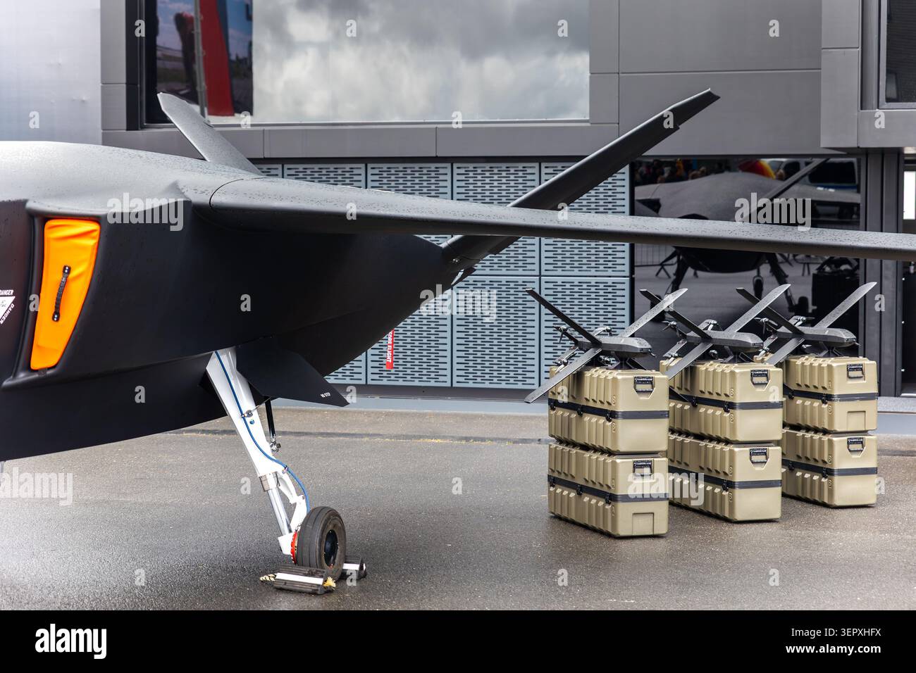 Vue de face du porte-missiles uav d'avion sans pilote avancé à l'extérieur de la chaussée mouillée ciel nuageux. Défense futuriste de surveillance de la technologie aérospatiale Banque D'Images