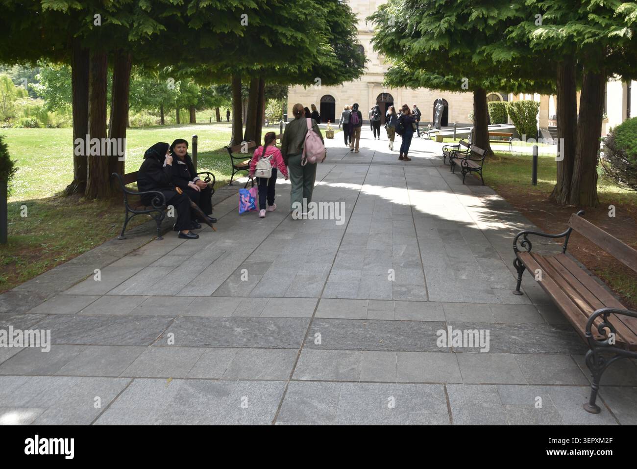 Après-midi tranquille dans un parc public avec des gens profitant d'une promenade paisible et assis ensemble Banque D'Images