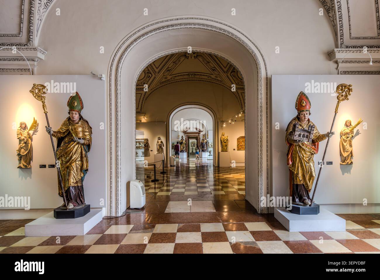 Deux statues médiévales tardives, plus grandes que nature, sculptées dans du bois doré - tous deux représentés comme des évêques portant des mitres et tenant des crosiers - flanquent un passage en arc de cercle dans l'exposition permanente de sculpture sacrée au DomQuartier à Salzbourg. DomQuartier, Kapitelplatz, Salzbourg, Autriche Banque D'Images