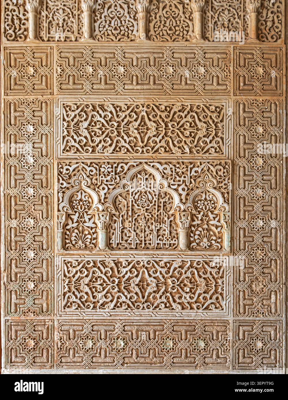 Un panneau mural magnifiquement structuré rempli de motifs géométriques complexes et de motifs en stuc mauresque sculptés à l'Alhambra de Grenade, en Espagne Banque D'Images
