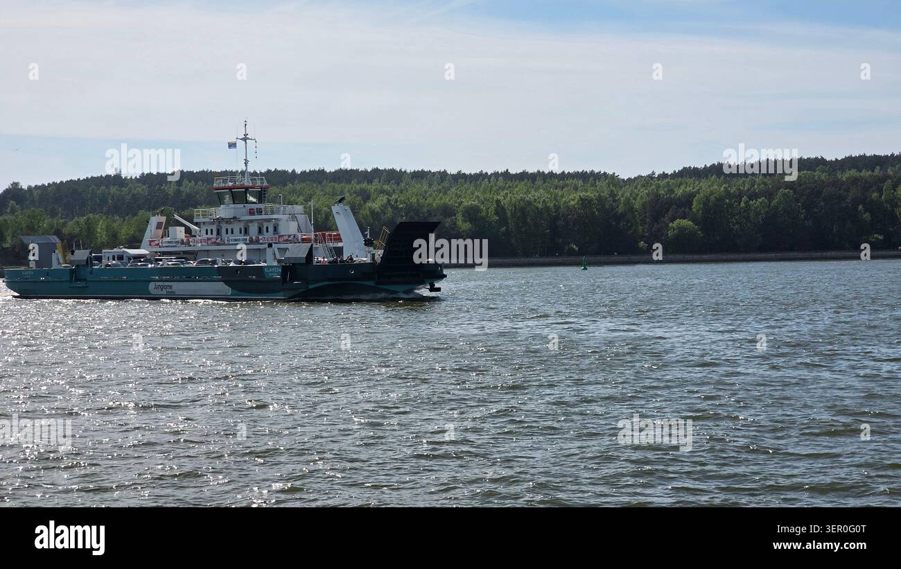 Klaipėda car ferry 'Jungiame krantus' traversant la lagune de Courlande avec le littoral boisé, Lituanie, été. Banque D'Images