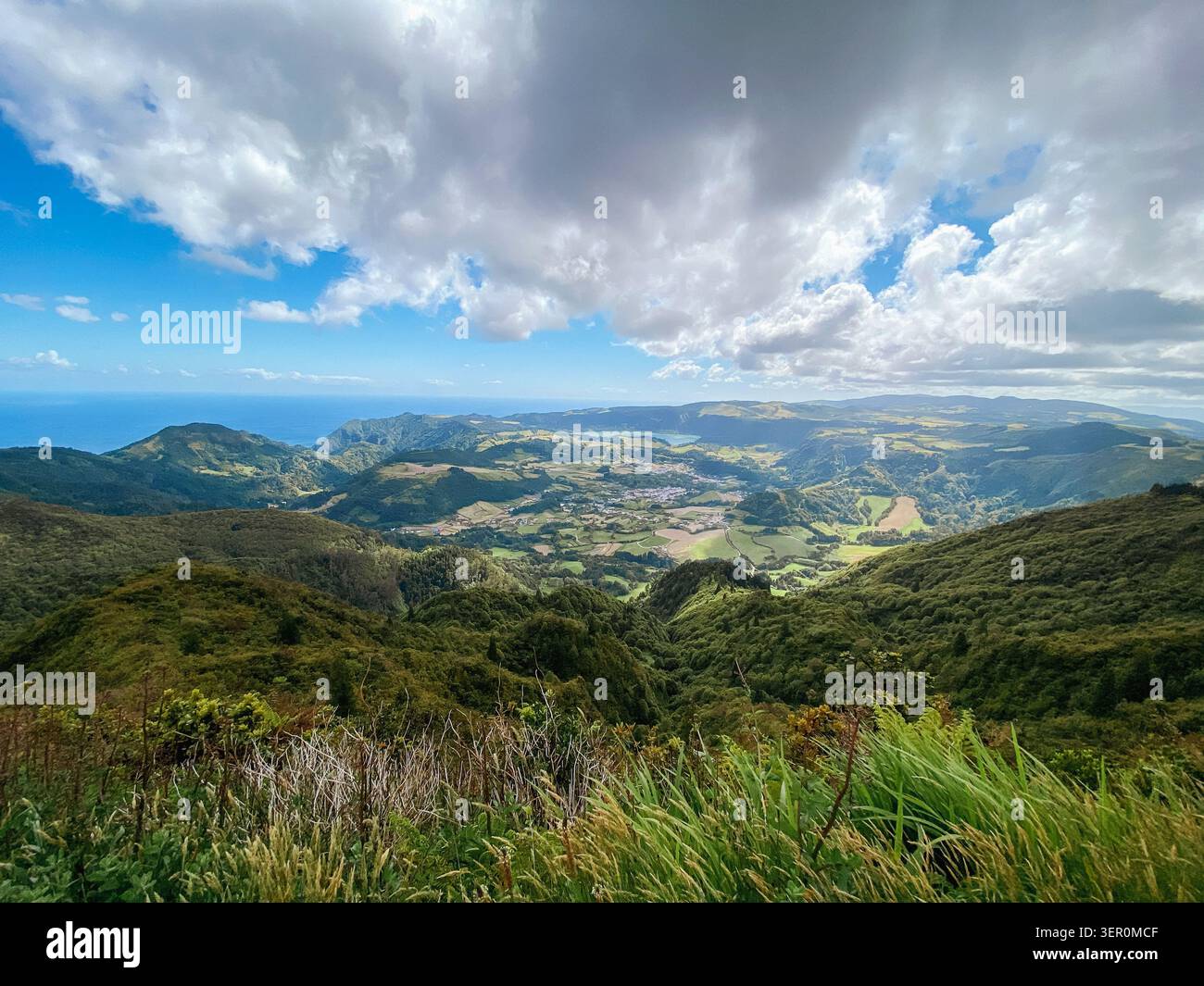 Panorama de vallée côtière avec des collines verdoyantes ondulantes sous des nuages dramatiques Banque D'Images