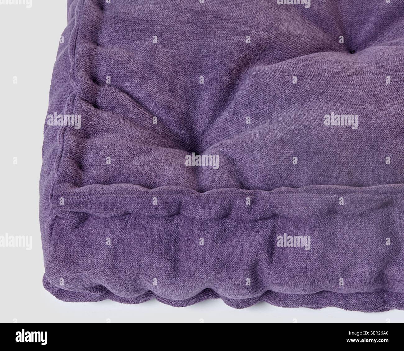 Coussin en velours violet avec coutures détaillées, offrant une sensation luxueuse et confortable Banque D'Images