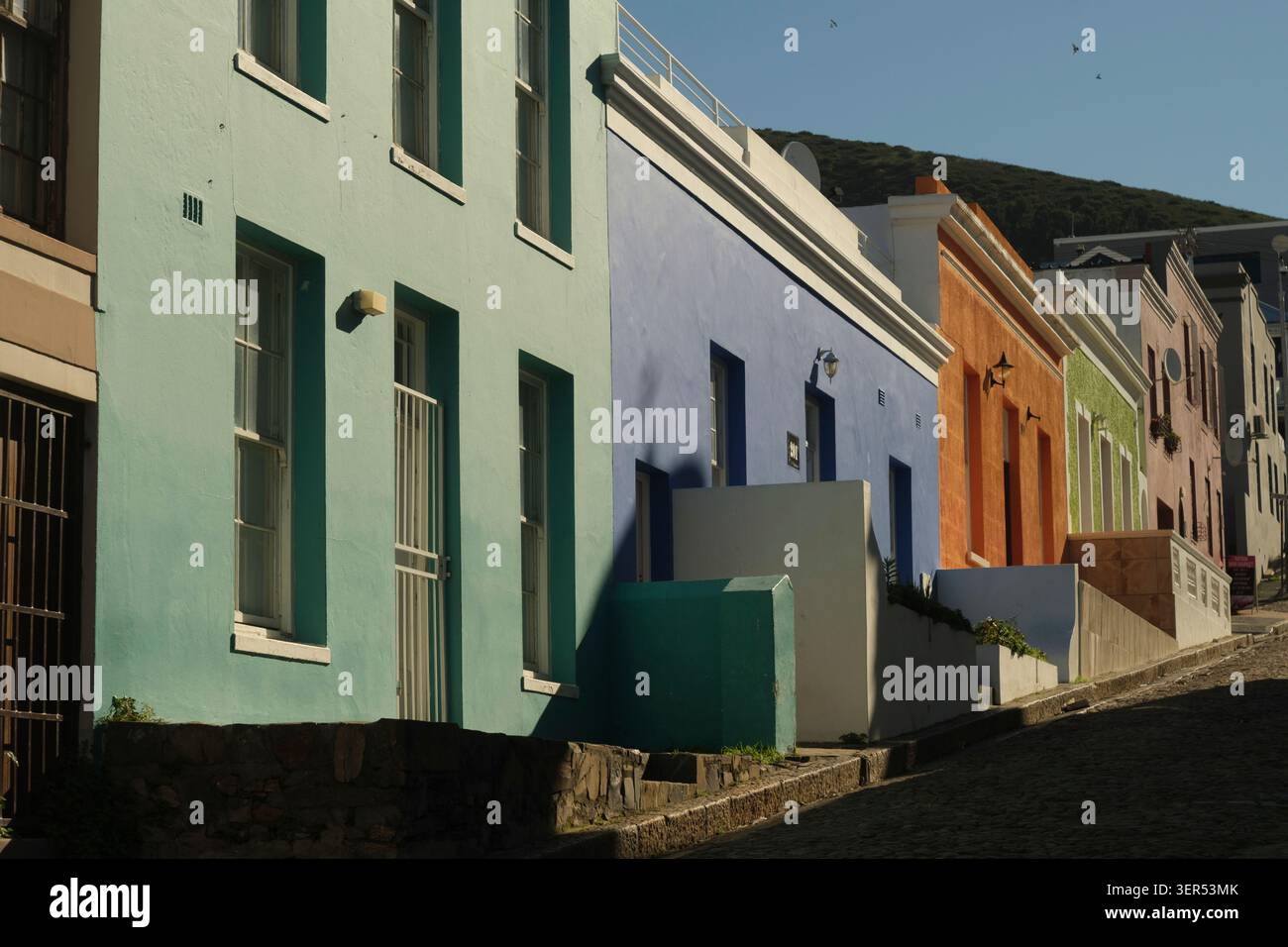Scène de rue calme des célèbres maisons colorées du quartier populaire et historique de Bo-Kaap, Le Cap, Afrique du Sud. Pris en fin d'après-midi. Banque D'Images
