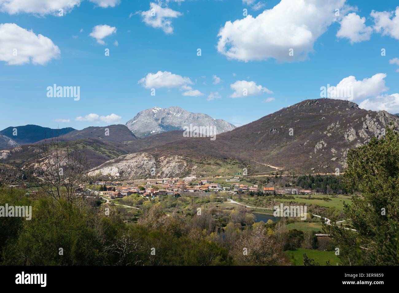 Vallée de montagne pittoresque avec un petit village, des champs verts et des routes sinueuses sous un ciel bleu avec des nuages, capturant la nature du nord de l'Espagne, voyage et Banque D'Images