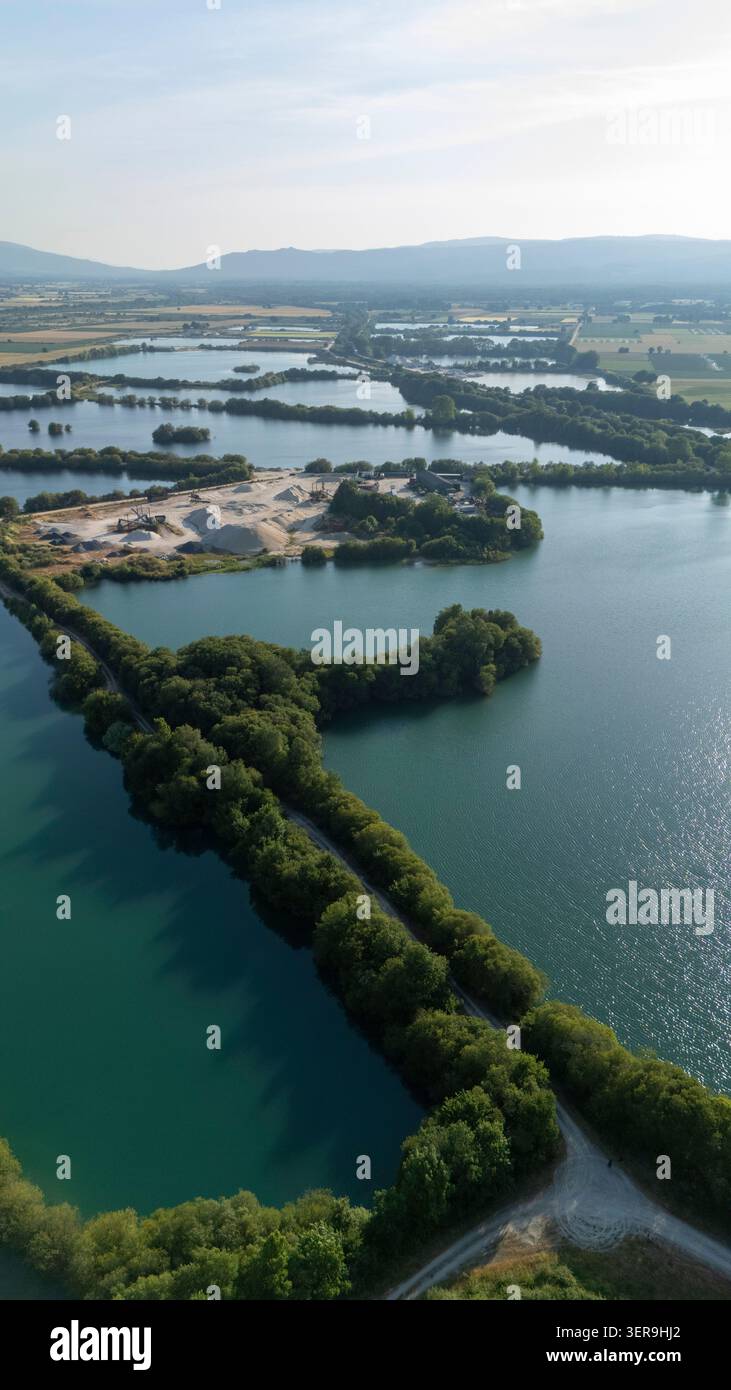 Vue aérienne montrant Lagoa da Lontra reliant plusieurs lacs, entourée d'arbres verdoyants et d'une carrière d'agrégats visible Banque D'Images