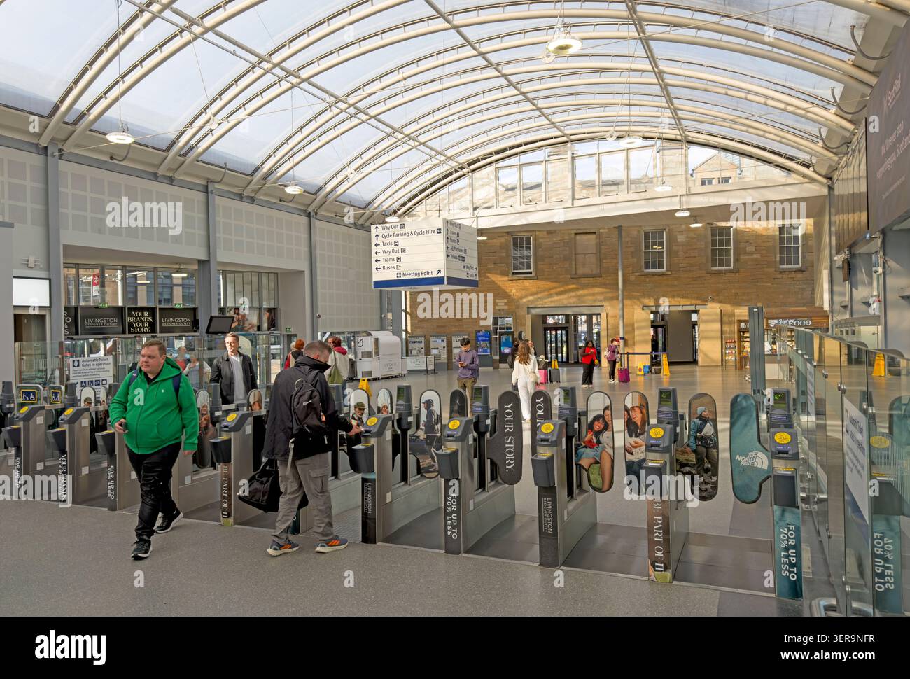 Les passagers passent à travers des barrières ferroviaires automatisées à l'intérieur de la gare de Haymarket rénovée, un important échangeur de transport d'Édimbourg Banque D'Images